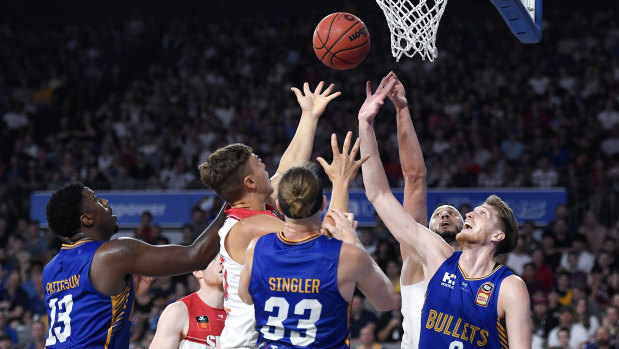 The Bullets and Hawks compete for the ball during the round 10 NBL match.