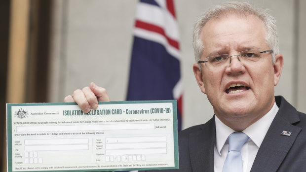 Prime Minister Scott Morrison holds up a Coronavirus Isolation Declaration Card as he also revealed plans to "hibernate" Australian businesses.
