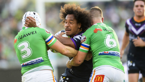 Felise Kaufusi of the Storm is tackled by Jarrod Croker and Jack Wighton of the Raiders.
