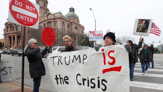 Protesters carry a sign in downtown Fort Worth, Texas, on Monday, Presidents' Day.