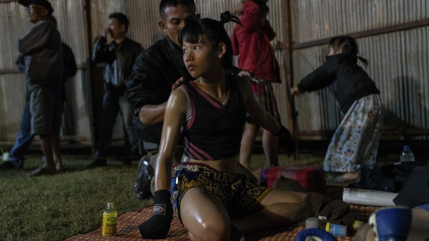 Supattra Inthirat, 12, known as Pancake, with her father before her fight at a small local fighting stage in That Phanom, Thailand.