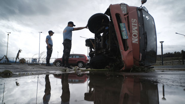 Police inspect a truck that was damaged as Typhoon Kammuri slammed Legazpi city, in south-east Manila.