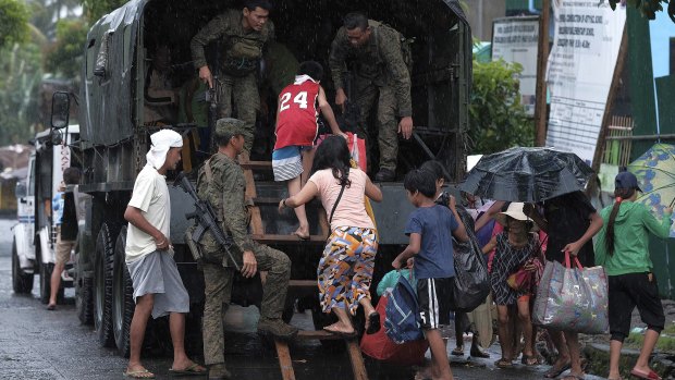 Residents in south-east Manila evacuate in a military truck before the typhoon hits.