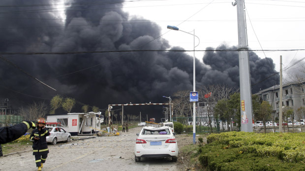Firefighters walk past the site of a factory explosion in Jiangsu province in eastern China.