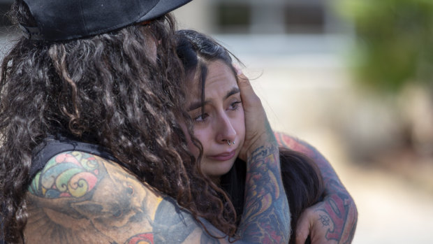 A couple embrace at the makeshift memorial for victims of the mass shooting at a shopping complex in El Paso, Texas. 