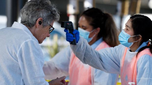 A woman has her temperature checked at the Sydney fish market as the nation deals with the COVID-19 crisis. 