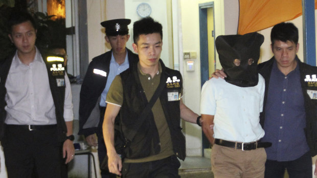 Hong Kong University associate professor Cheung Kie-chung is escorted to the alleged murder scene on Wednesday.