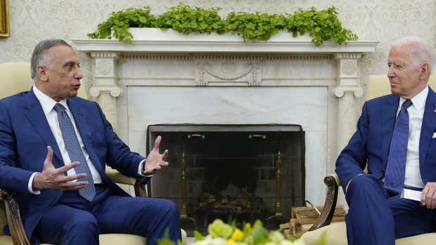 US President Joe Biden, right, listens as Iraqi Prime Minister Mustafa al-Kadhimi speaks during their meeting in the Oval Office.