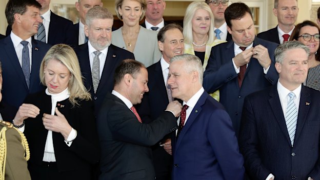 Members of the ministry put on Australian flag pins given to them by new Prime Minister Scott Morrison. 