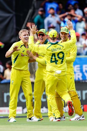 An ecstatic Australian side after claiming the wicket of Virat Kohli.