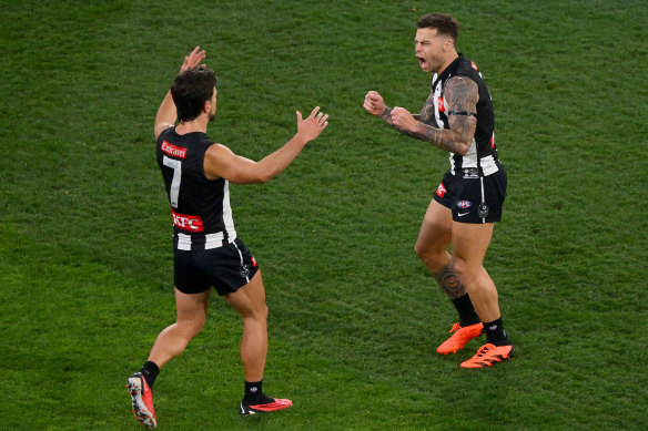 Josh Daicos and Jamie Elliott of the Magpies celebrate a goal.