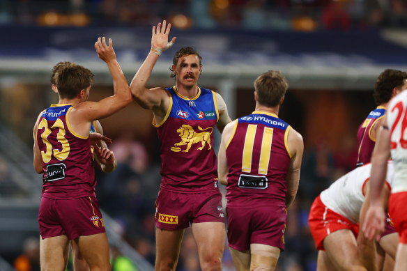 Joe Daniher and his teammates celebrate a goal for the Lions.