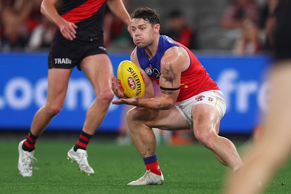 Lachie Neale, dos Leões, marca a bola.
