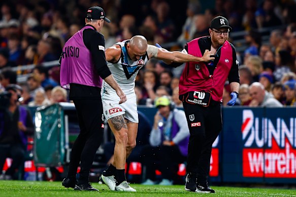 Sam Powell-Pepper of the Power is helped from the ground.