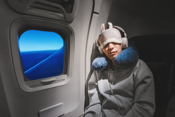 There’s an art to falling asleep within the cramped chaos of a packed plane.