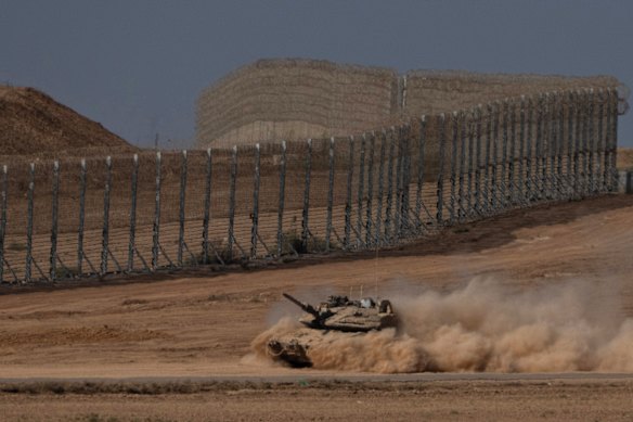 An Israeli tank moves through an area near the Israeli-Gaza border on Wednesday.
