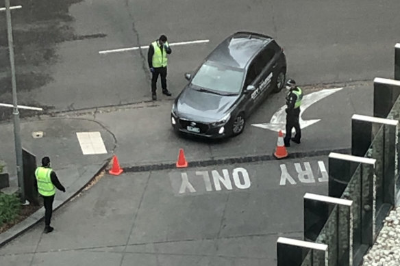 Guards and police at the entry of Crown Promenade last week. The hotel is one of 15 "quarantine hotels" in central Melbourne where returned travellers must spend 14 days in mandatory isolation.