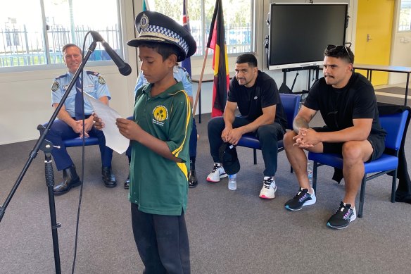 Latrell Mitchell and Cody Walker with police officers and a pupil from Cabbage Tree Island Public School.