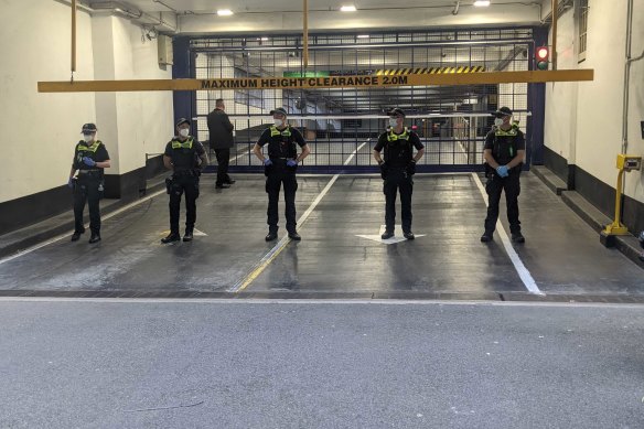 About a dozen Victoria Police officers and several private security guards at the entrance to Novak Djokovic’s lawyer’s carpark.