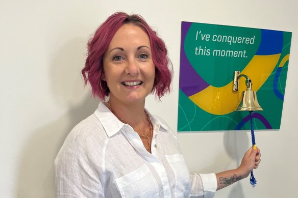Rachael Brooks-Donald with the bell that is traditionally rung to signal the end of breast cancer treatment.