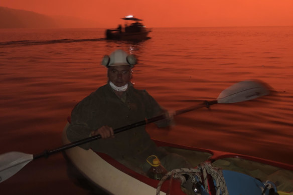 Justin Brady, whose home was destroyed in the fire, seeks refuge on the water in his canoe at Mallacoota.