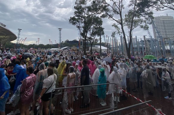 Fans wait in the rain outside Accor Stadium.