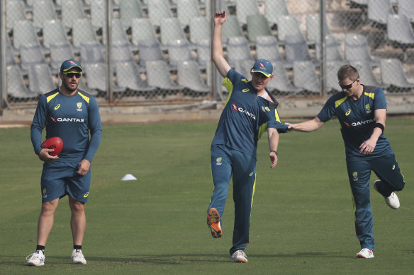 Australia's captain Aaron Finch, left, Marnus Labuschagne, center. and Steve Smith warm up at training in Mumbai.