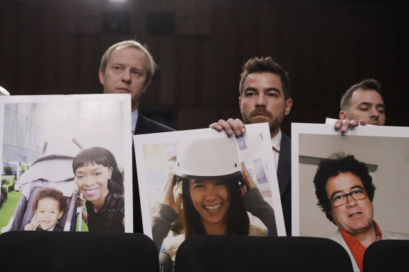 Family members of crash victims holding up photographs of their loved ones at a US Senate hearing last year.