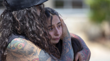 A couple embrace at the makeshift memorial for the victims of Saturday mass shooting at a shopping complex in El Paso, Texas.