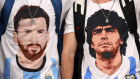 More than a religion. Fans in Doha sport shirts with the images of Lionel Messi and Diego Maradona. 