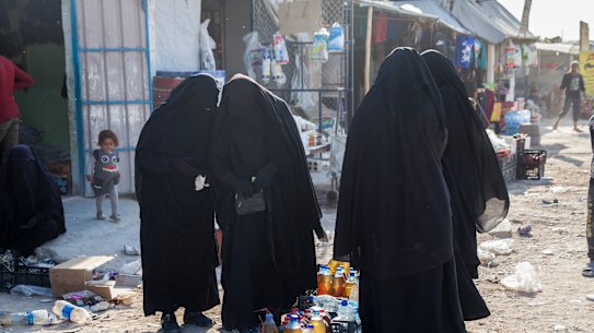 Women buy food at Al Hawl camp, Syria.