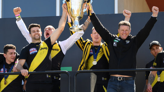 Trent Cotchin and Damien Hardwick lift the 2019 premiership cup with Dustin Martin and Jack Riewoldt behind.
