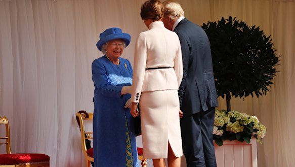 Queen Elizabeth II, left, smiles as she greets President Donald Trump and First Lady Melania Trump at Windsor Castle.