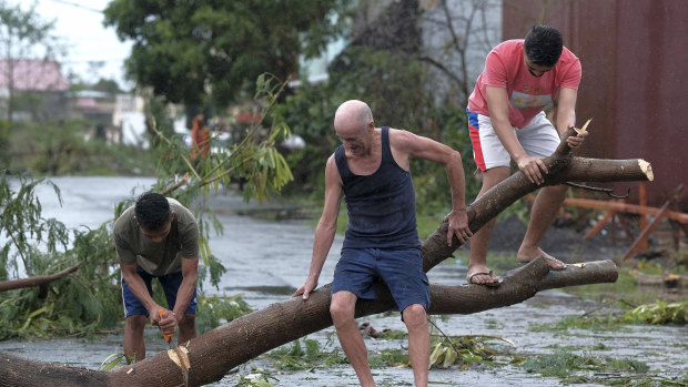 Men cut down a tree that fell due to strong winds as Typhoon Kammuri slammed Legazpi city, Albay province, southeast of Manila, Philippines, earlir this month.