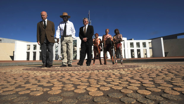 Parliament House architects Romaldo Giurgola (left) and Ric Thorp (in black suit) with artist Michael Nelson Jagamara (wearing hat) at Parliament House in 2008.