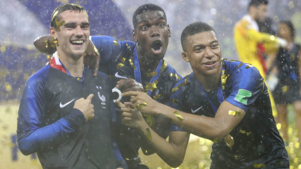 From left: Antoine Griezmann, Paul Pogba and Kylian Mbappe celebrate their World Cup win.