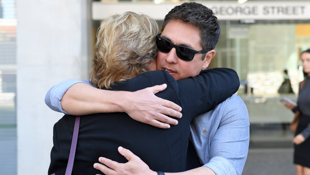 The brother of Fabiana Palhares, Raphael Palhares (right), is consoled after leaving the Supreme Court in Brisbane.