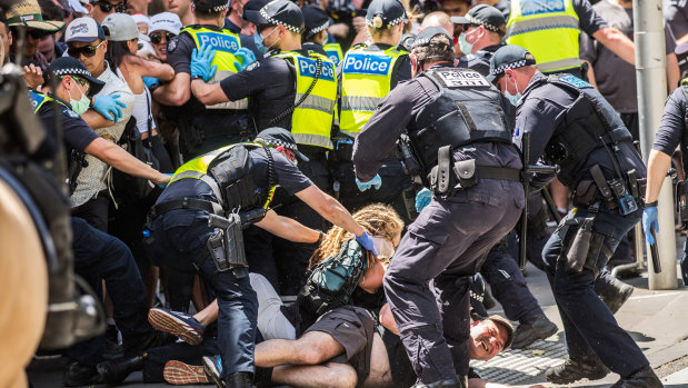 Anti-lockdown protestors and police outside the Victorian Parliament on Cup Day.