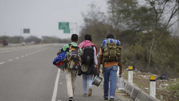 Venezuelan Omar Mujica, right, walks to Lima along the shoulder of the Pan-American Highway with other Venezuelan migrants.