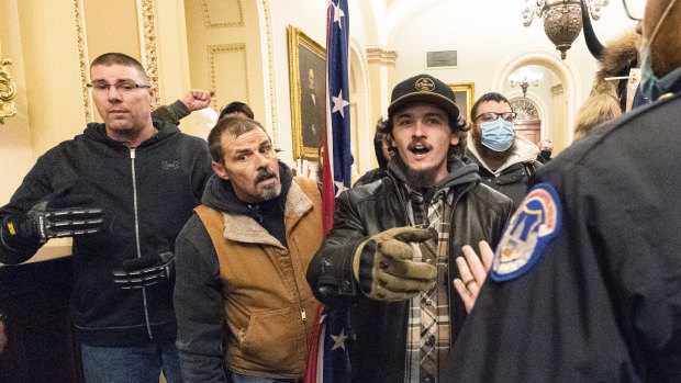 Violent protesters loyal to President Donald Trump are confronted by US Capitol Police officers outside the Senate Chamber inside the Capitol, during the riots. 