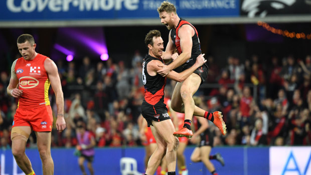 Stringing it out: Essendon forward Jake Stringer (right) celebrates with Mitch Brown after scoring a late goal to help seal a fighting win for the Bombers over the Suns.