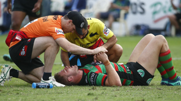Down time: Tom Burgess is treated after being whacked off the ball by Elliott Whitehead.