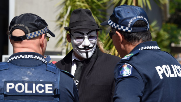 Police officers talk to an activist outside the Brisbane Magistrates Court. He was there to support G20 protesters.