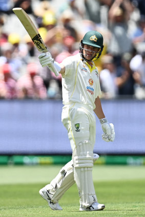 Harris raises his bat after passing 50. 