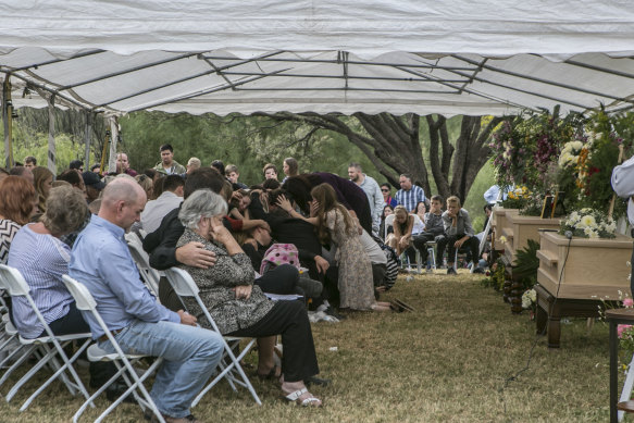 Family members embrace during the funeral service for Dawna Langford and her two children, Trevor and Rogan.