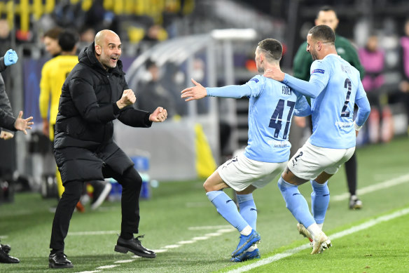 Pep Guardiola celebrates with Phil Foden.