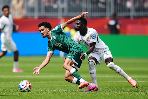Iraq’s Zidane Iqbal and Senegal’s Lamine Camara battle for the ball in Toronto.