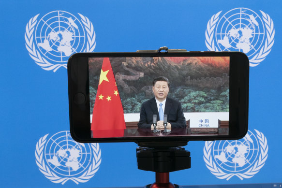 Chinese President Xi Jinping is seen on a phone screen remotely addressing the 75th session of the United Nations General Assembly.