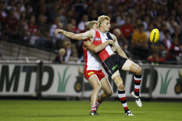 Nick Riewoldt shoots at goal as Craig Bolton tries to tackle.