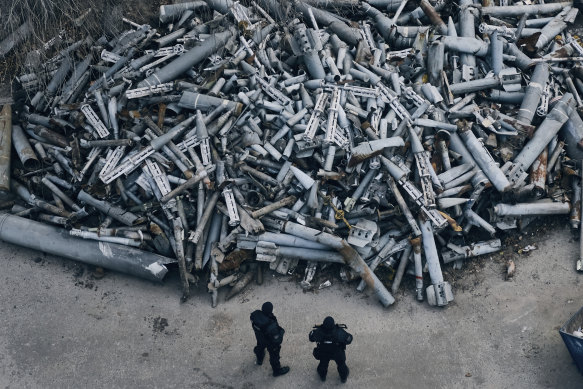 Police officers look at collected fragments of the Russian rockets that hit Kharkiv, Ukraine.